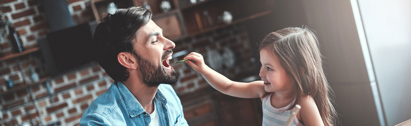 Father and daughter eating in kitchen